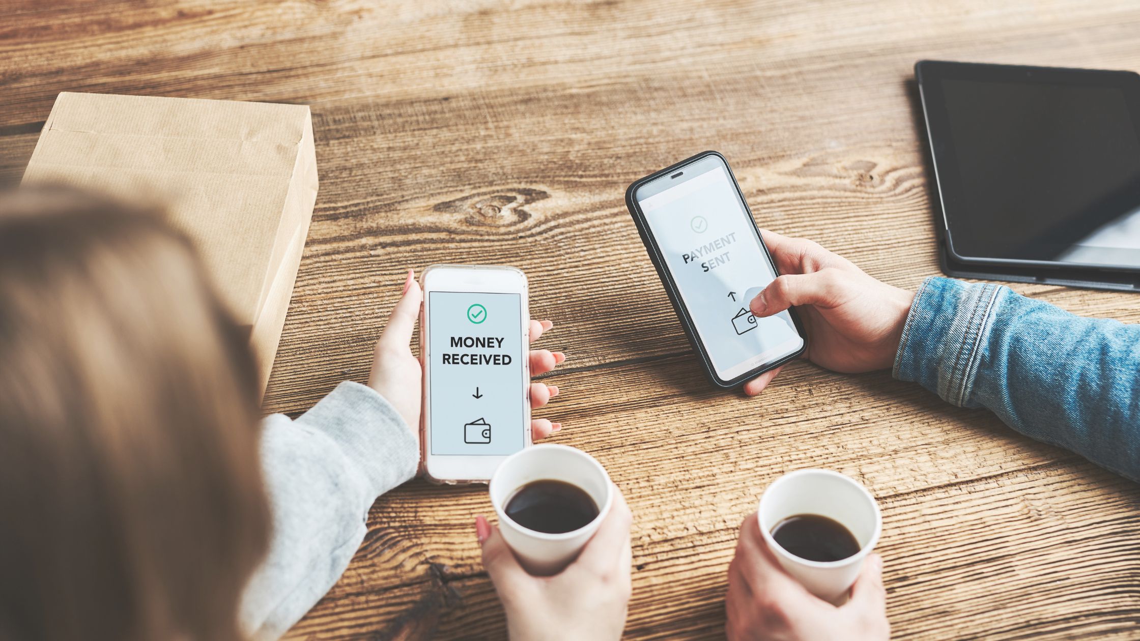 2 people holding their mobile devices while sending money using the SWIRL Card App