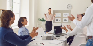 An image of an employee being applauded by their colleagues making them feel valued and appreciated