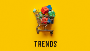 An image of a trolley full of wrapped presents on a yellow background with the word “trends” underneath.